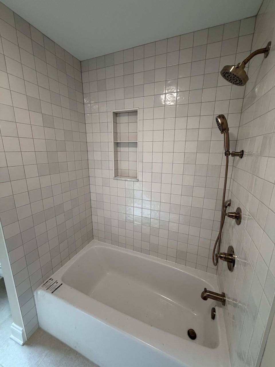 White tile shower with fixtures
