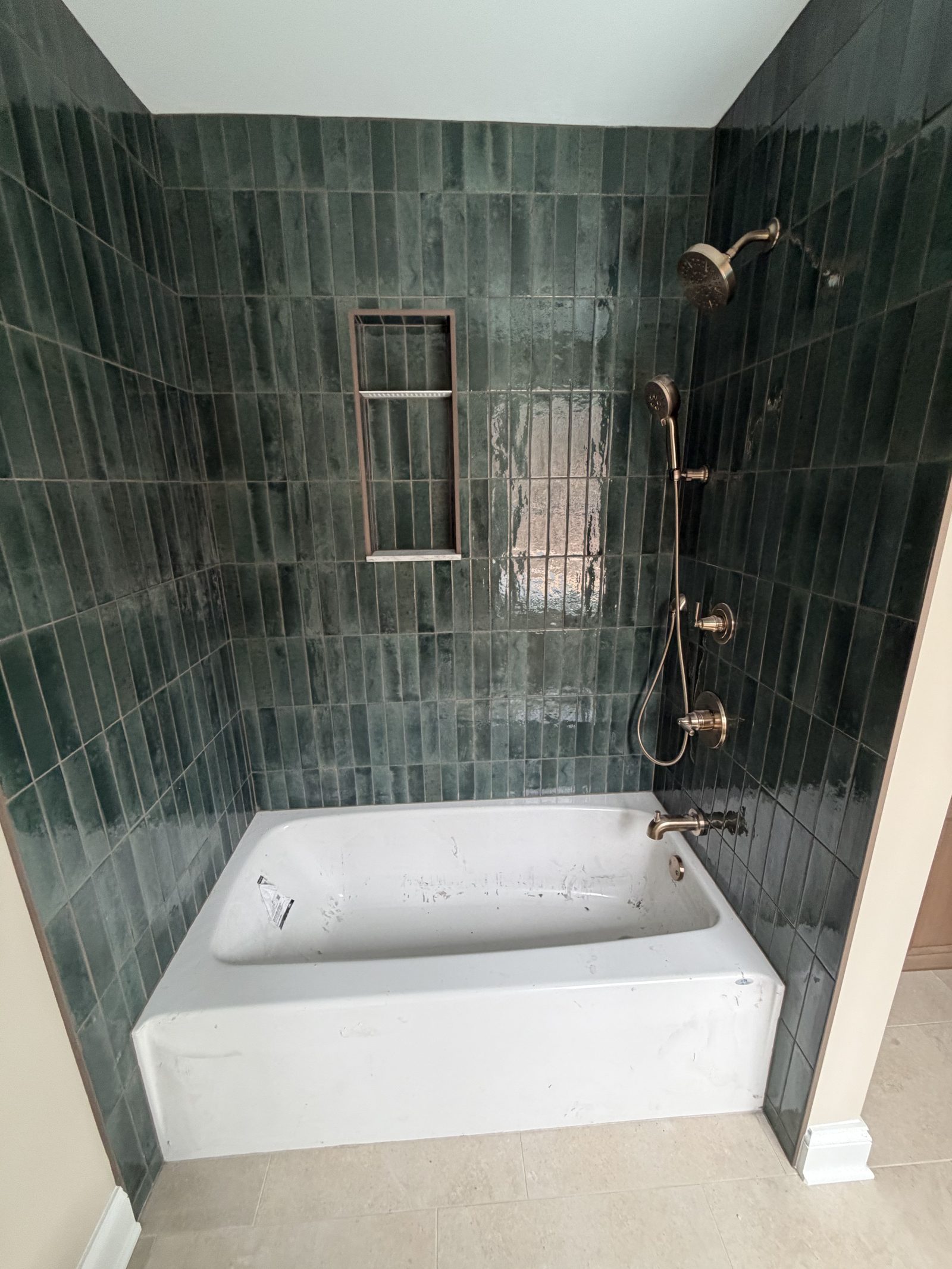 Bathroom with green tile tub surround